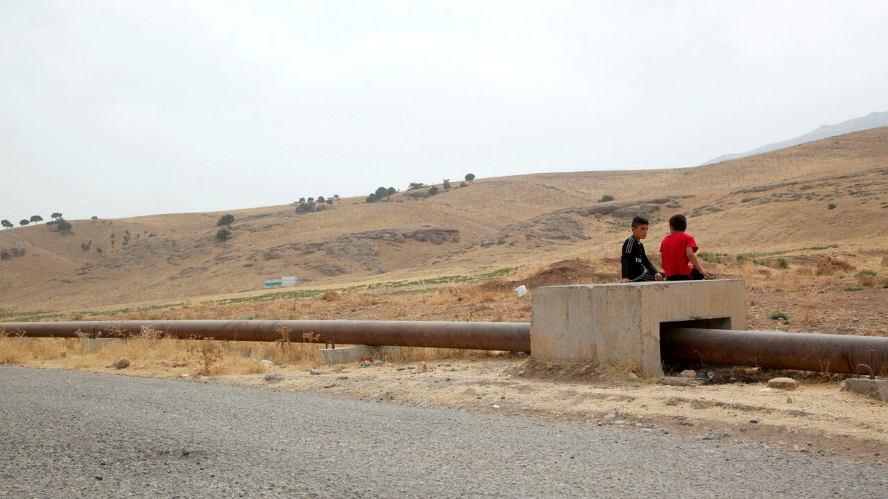 FILE PHOTO: Boys sit on the Iraqi-Turkish pipeline in Zakho district of the Dohuk Governorate of the Iraqi Kurdistan province, Iraq, August 28, 2016.  REUTERS/Ari Jalal/File Photo
