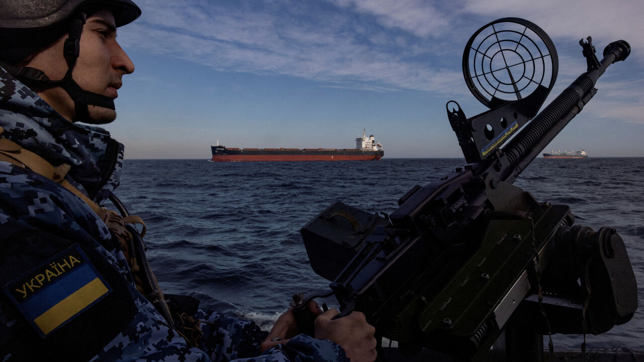 FILE PHOTO: A serviceman in Ukraine's coast guard mans a gun on a patrol boat as a cargo ship passes by in the Black Sea, February 7, 2024. REUTERS/Thomas Peter/File Photo