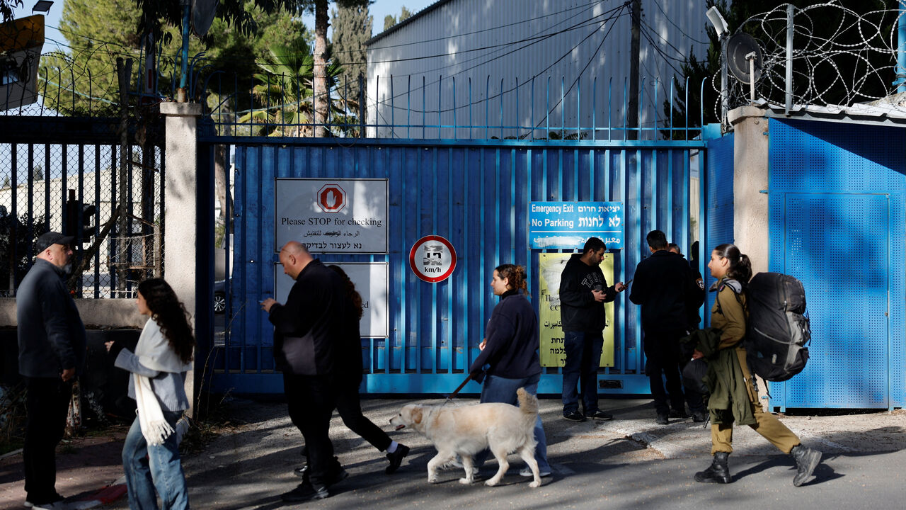 People walk outside the United Nations Relief and Works Agency for Palestine Refugees (UNRWA) headquarters, in Jerusalem December 8, 2025. REUTERS/Ammar Awad