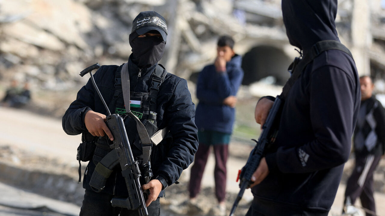 Palestinian Hamas militants stand at a site as Hamas says it continues to search for the body of the last deceased hostage, in Gaza City December 8, 2025.REUTERS/Dawoud Abu Alkas