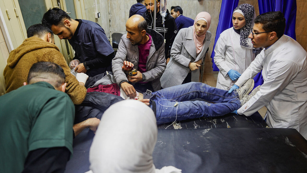 Paramedics place a wounded person on a stretcher inside a hospital, during a wave of attacks by government forces and the Kurdish-led Syrian Democratic Forces in the northern Syrian city of Aleppo, December 22, 2025. REUTERS/Karam al-Masri