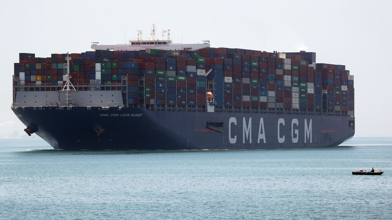 A fisherman travels on a boat in front of a CMA CGM container ship passing through the Suez Canal in Ismailia, Egypt July 7, 2021. Picture taken July 7, 2021. REUTERS/Amr Abdallah Dalsh