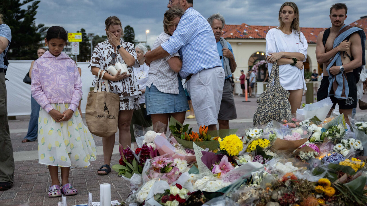 People mourn near floral tributes placed for victims and survivors of a deadly mass shooting during a Jewish Hanukkah celebration at Bondi Beach on December 14, in Sydney, Australia, December 21, 2025. REUTERS/Eloisa Lopez