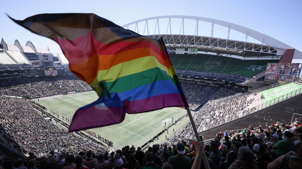A fan waves a Pride flag before the soccer match between the Seattle Sounders and the Portland Timbers at Lumen Field, on June 3, 2023, in Seattle, Washington.