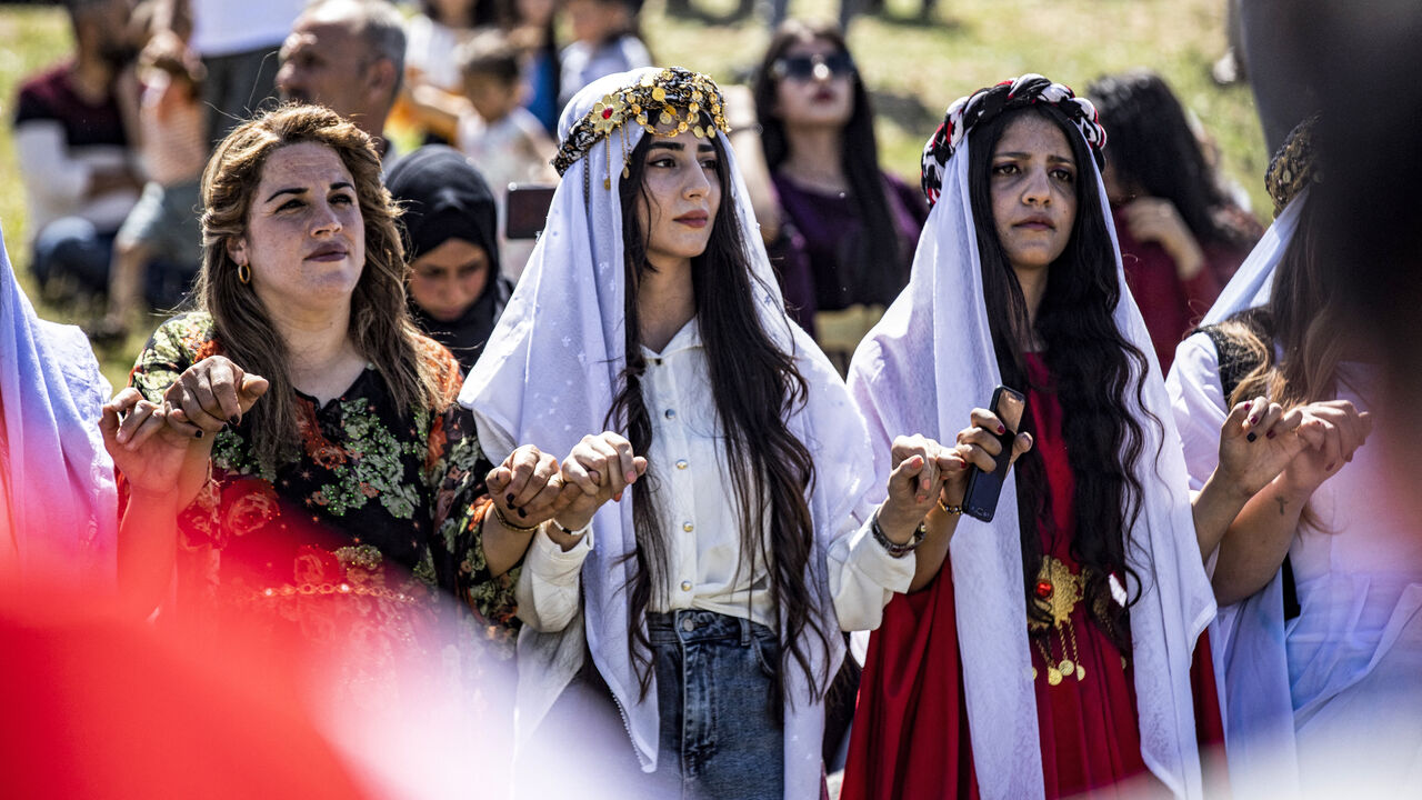 Syrian Yazidi women dressed in traditional clothing dance with other revelers during a ceremony marking the Yazidi New Year in the Kurdish village of Dogir near Amuda in northeastern Syria on April 17, 2024. 
