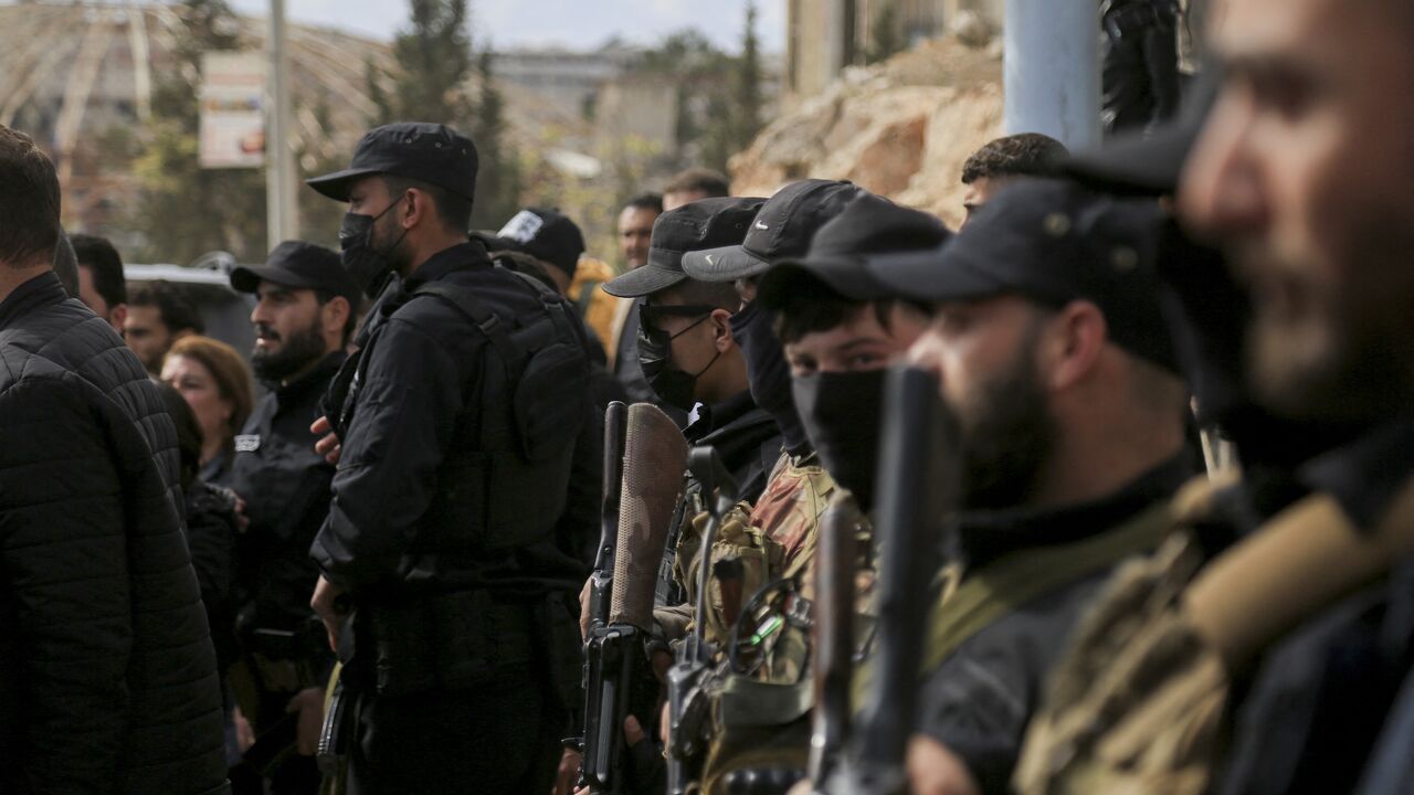 Armed personnel of SDF and public security forces of the new Syrian government stand guard in al-Ramun district of Aleppo, Syria, on April 3, 2025. 