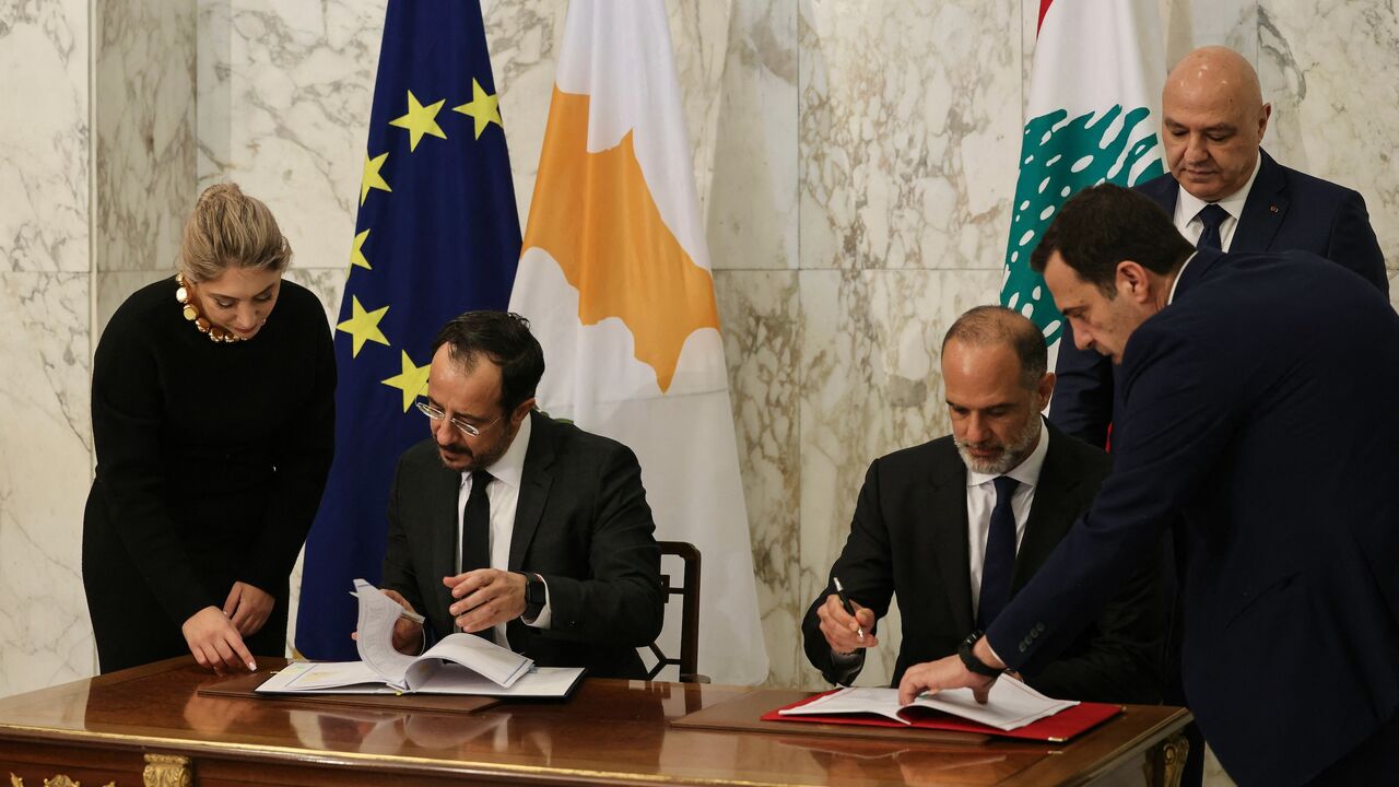 Cypriot President Nikos Christodoulides signs documents with Lebanese Minister of Public Works and Transport Fayez Rasamny, as Lebanon's president, Joseph Aoun, looks on during an agreement signing ceremony at the presidential palace of Baabda, east of Beirut, on Nov. 26, 2025. 