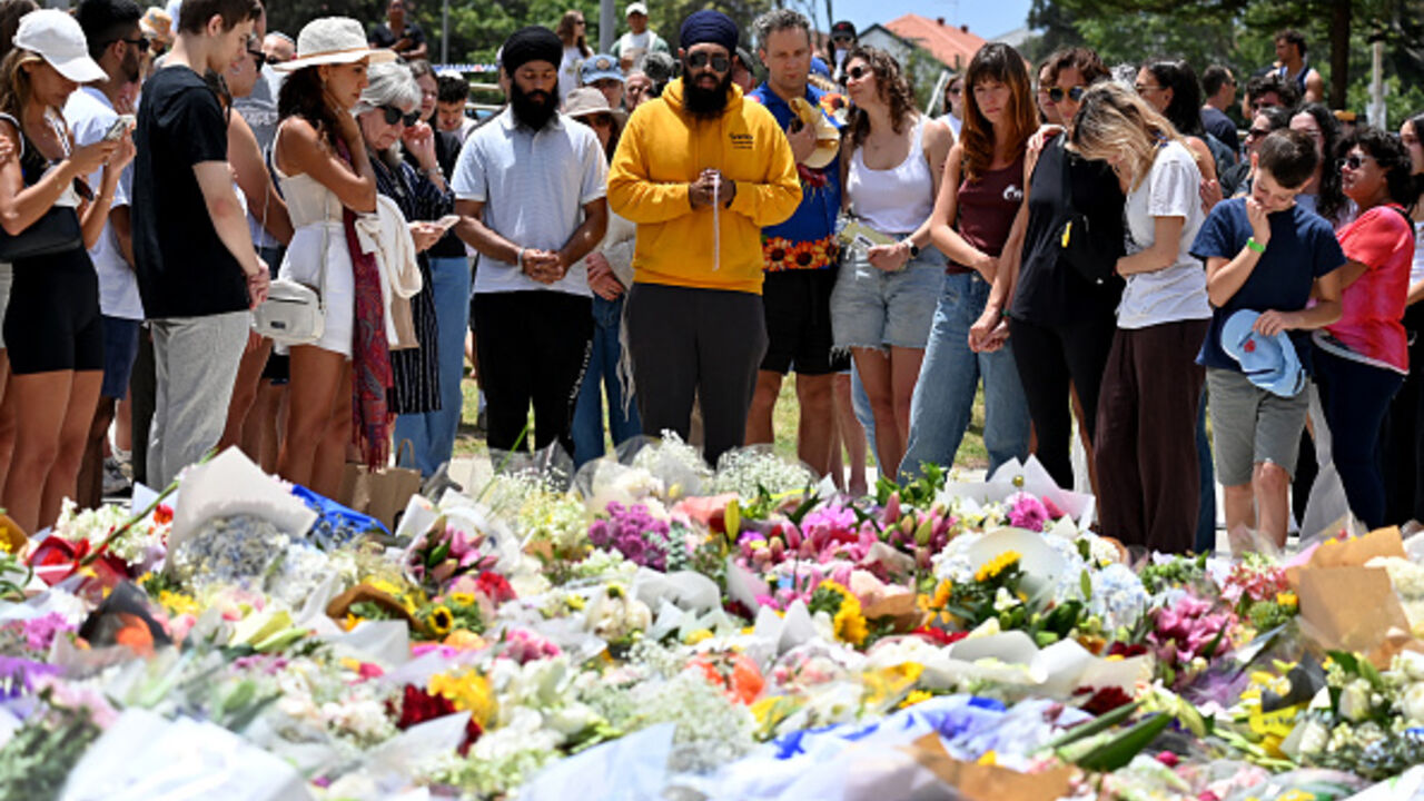 Mourners gather by floral tributes at the Bondi Pavilion in memory of the victims of a shooting at Bondi Beach, in Sydney on December 15, 2025. (Saeed KHAN / AFP via Getty Images)