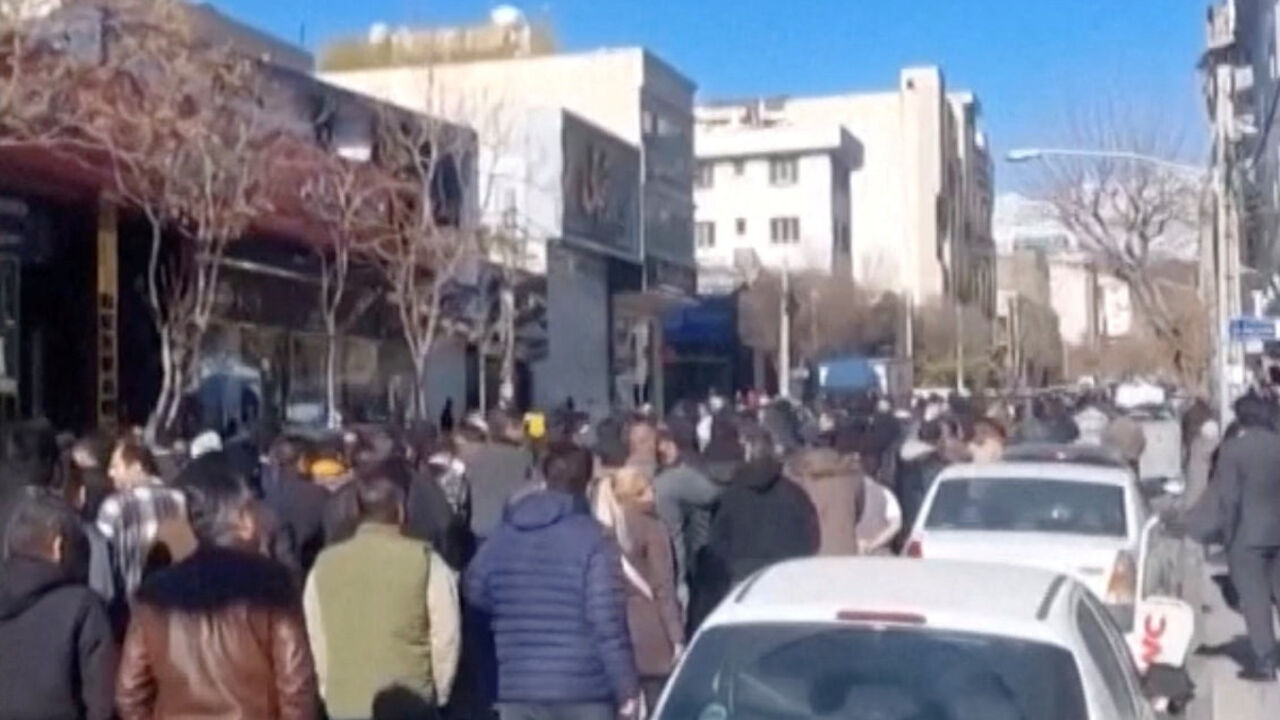 People walk down the street, chanting in Farsi, "Reza Shah, rest in peace", in Tehran, Iran, in this still image obtained from a social media video released on December 30, 2025. Social Media/via REUTERS