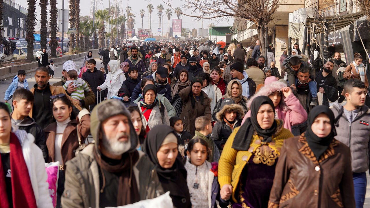 A group of civilians carry bags and belongings as they flee following renewed clashes between the Syrian army and the Syrian Democratic Forces, in Aleppo, Syria, January 7, 2026. REUTERS/Karam al-Masri