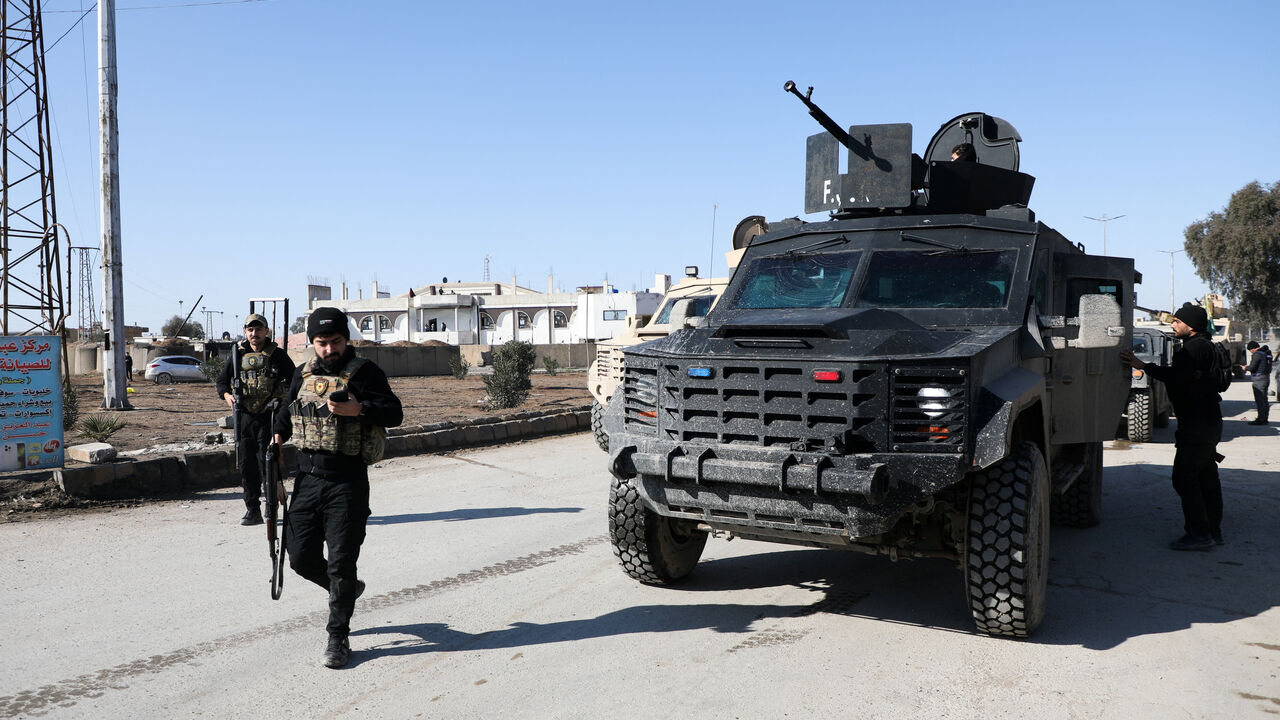 Syrian Democratic Forces (SDF) fighters walk near an armored vehicle, following clashes between SDF and Syrian government forces, in Hasakah, Syria, January 20, 2026. REUTERS/Orhan Qereman