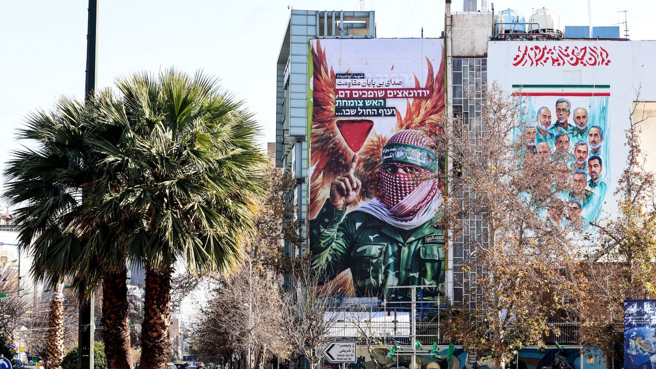 A large anti-Israeli banner portraying an image of a Palestinian fighter and the slogan in Persian and Hebrew, "Endless Voice of Resistance," is erected in Palestine Square in Tehran on Dec. 31, 2025, after Israel's Mossad spy agency issued a direct call urging Iranians to press on with protests. 