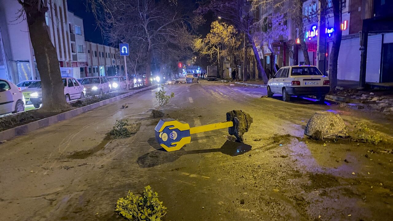 Rocks, tree branches, and a toppled charity box remain on a street during unrest amid demonstrations in Hamedan, Iran, on Jan. 1, 2026