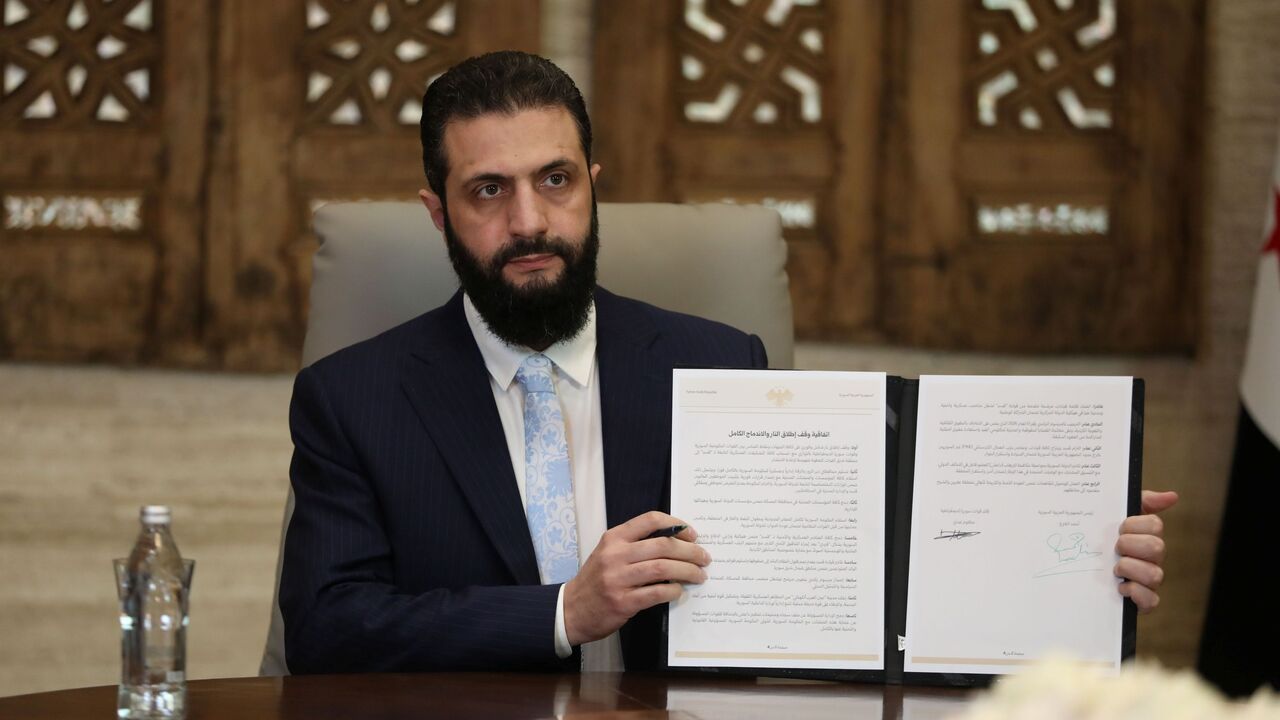 DAMASCUS, SYRIA - JANUARY 18: Syrian President Ahmed Al-Sharaa signs a ceasefire agreement with the Kurdish-led Syrian Democratic Forces (SDF) on January 18, 2026 in Damascus, Syria. According to Syrian state media, the deal includes a handover of Deir ez-Zor and Raqqa governates into government control, and the full integration of SDF fighters into state institutions. It follows the government's recent push towards the key city of Raqqa, after SDF fighters withdrew from Aleppo amid deadly clashes over the 