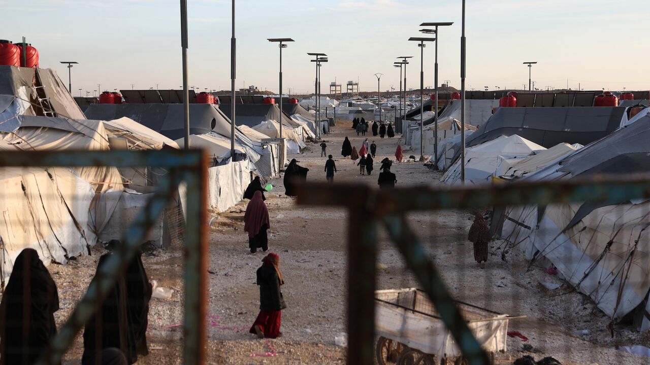 Children and women, relatives of suspected Islamic State jihadists, walk inside al-Hol camp in the desert region of Syria's northeastern Hasakah province, on Jan. 21, 2026.