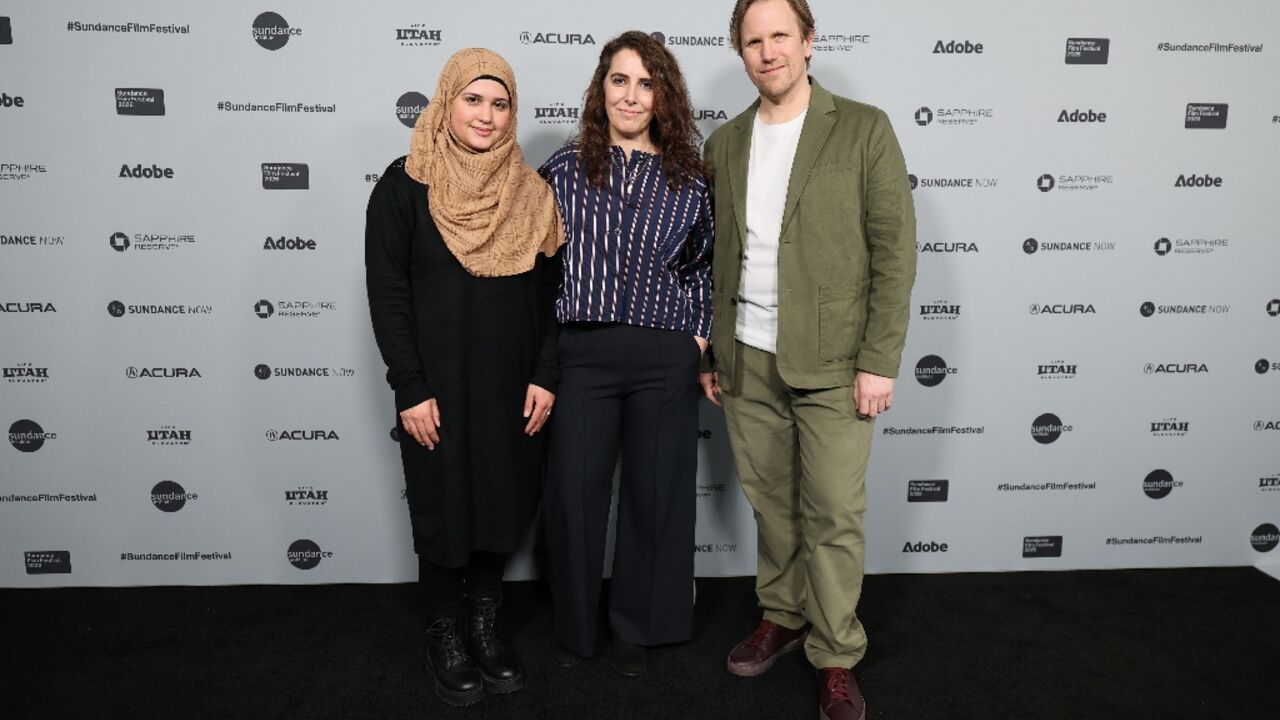 Syrian refugee Isra’a (L) stands alongside directors Itab Azzam and Jack MacInnes at the "One In A Million" premiere during the 2026 Sundance Film Festival