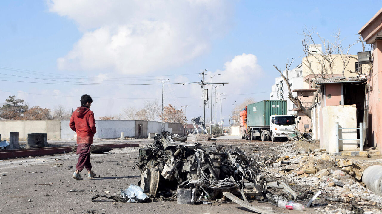 A person walks past the remains of a damaged vehicle at a site, after militant attacks, in Quetta, Pakistan, February 1, 2026. REUTERS/Stringer