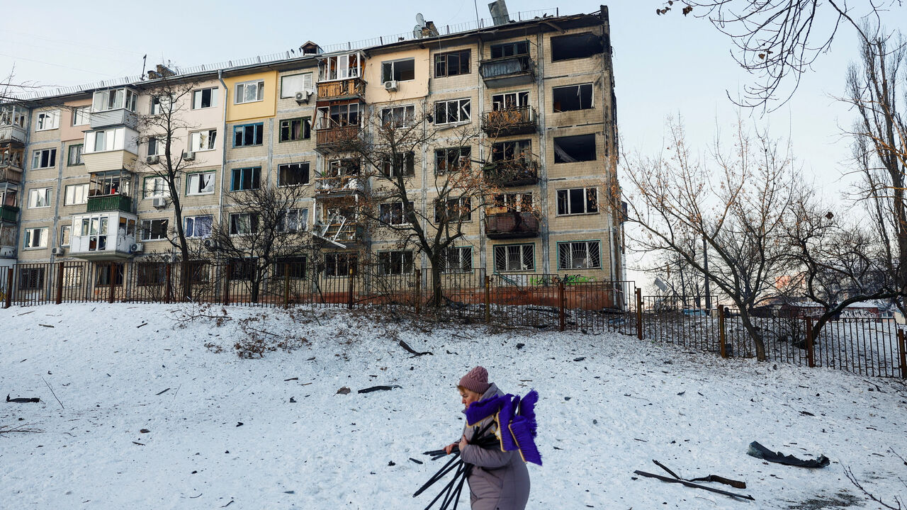 A woman, who is a school employee, walks near the site of an apartment building hit by a Russian drone strike, amid Russia's attack on Ukraine, in Kyiv, Ukraine February 3, 2026. REUTERS/Valentyn Ogirenko