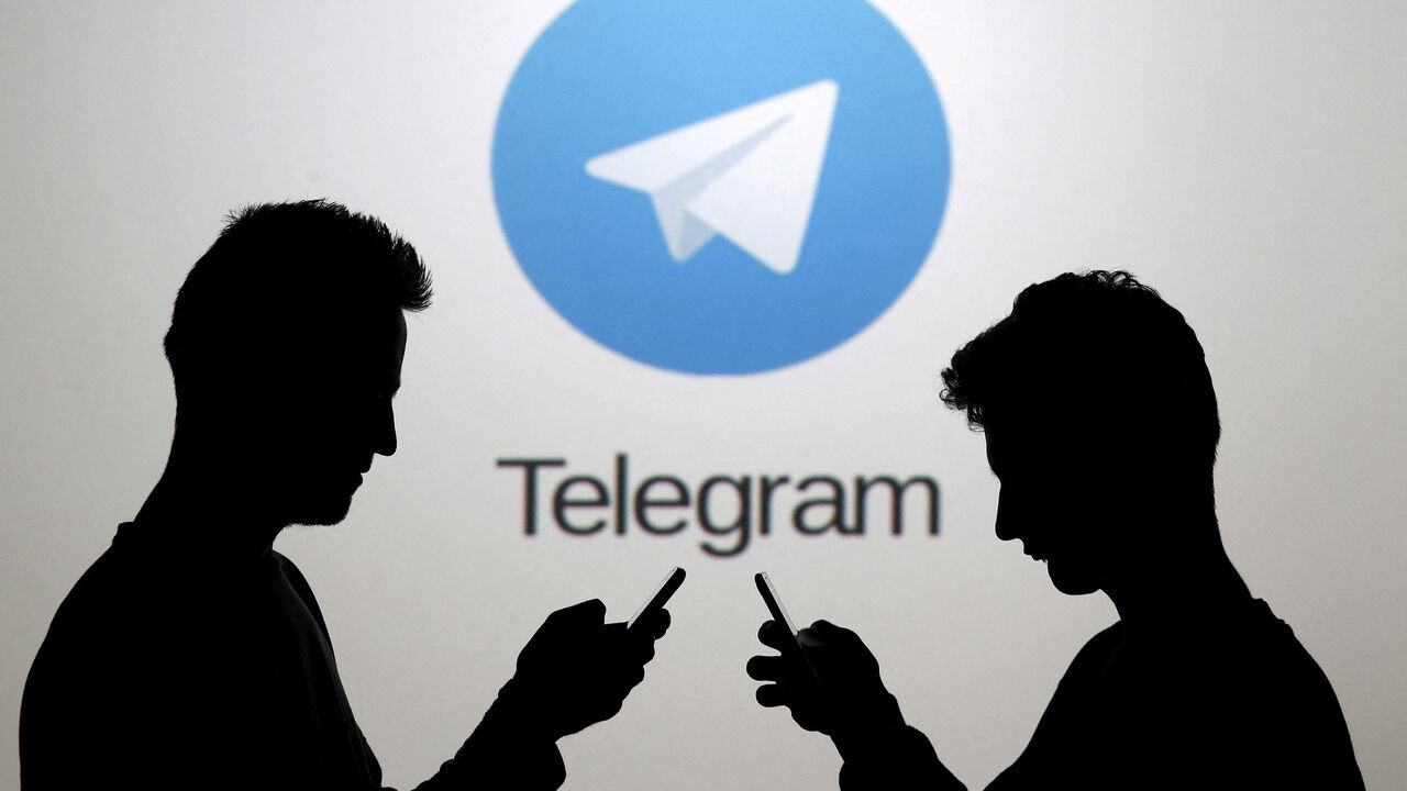 FILE PHOTO: Two men pose with smartphones in front of a screen showing the Telegram logo in this picture illustration taken in Zenica, Bosnia and Herzegovina November 18, 2015.  REUTERS/Dado Ruvic/File Photo