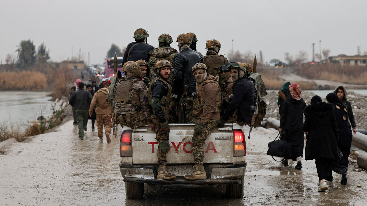 FILE PHOTO: Military personnel in a vehicle at the crossing connecting the two banks of the Euphrates River, as they attempt to cross to the other side after the Syrian Democratic Forces (SDF) withdrew from Deir al-Zor province and the Syrian army took full control over the area, in Deir al-Zor, Syria, January 18, 2026. REUTERS/Khalil Ashawi/File Photo