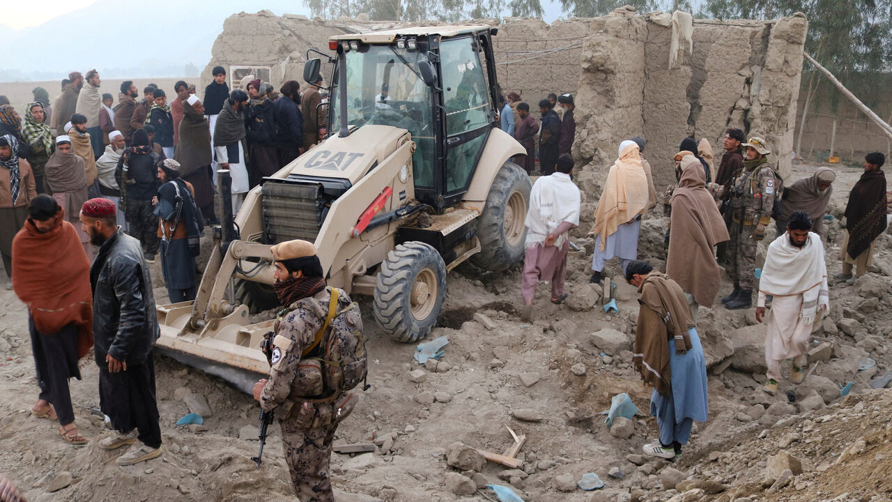 FILE PHOTO: Residents gather near a damaged house as a loader clears debris, following the Pakistani airstrikes, in Bihsud district, Nangarhar province, Afghanistan, February 22, 2026. REUTERS/Stringer/File Photo