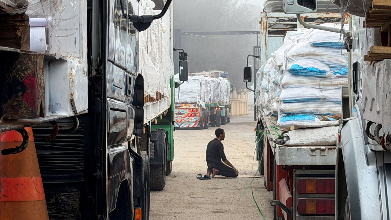 FILE PHOTO: An Egyptian man prays next to trucks carrying humanitarian aid and fuel lined up at the Rafah border to cross into the Gaza Strip, on the Egyptian side, in Rafah, Egypt, February 10, 2026. Picture taken with a mobile phone. REUTERS/Stringer/File Photo