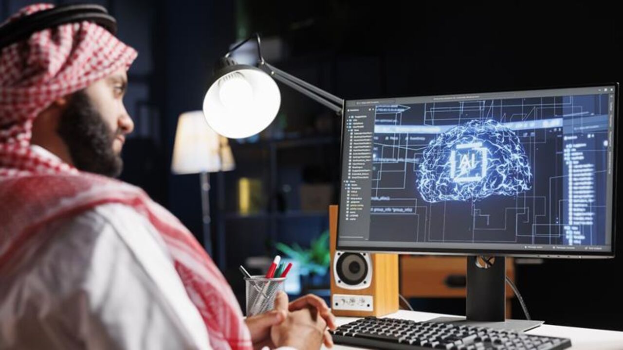 Detailed image of Middle Eastern developer in front of desktop pc monitoring a complex network, ensuring data security and efficient computing using cloud, AI and machine learning. — Getty Images