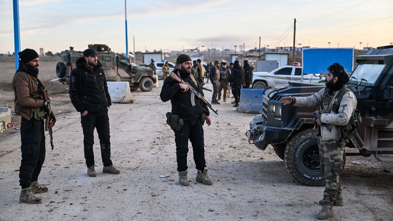 Members of Syrian security forces at the entrance of the al-Hol camp in the desert region of Hasakah province which holds around 24,000 people, including some 6,200 women and children from around 40 nationalities on Jan. 21, 2026 in Al Hasakah, Syria.  