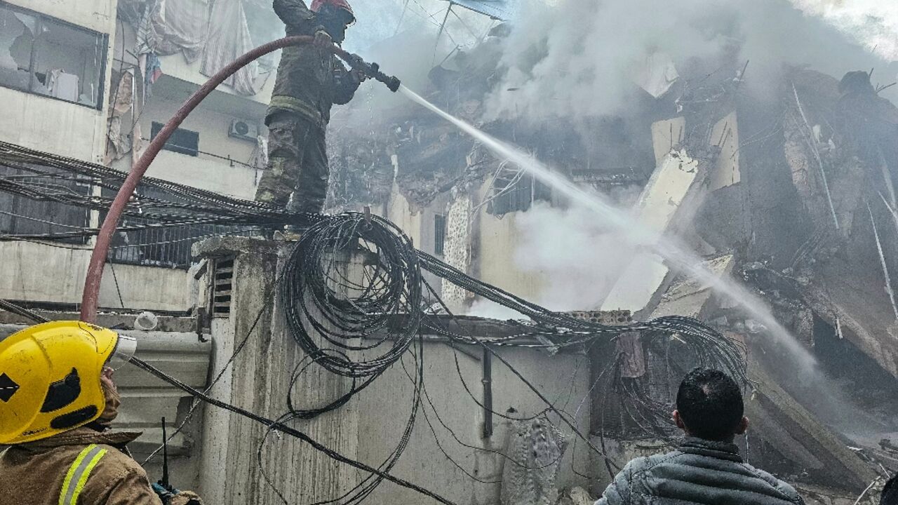 Firefighters at a site  of an Israeli air strike in Beirut’s southern suburbs