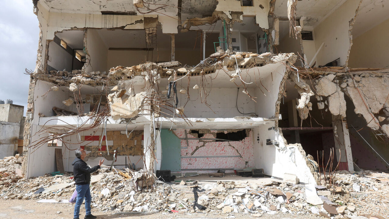 Khiam resident, Hussain Khrais stands in front of his store that was damaged during the latest hostilities between Israel and Lebanon, in Khiam village, near the border with Israel, southern Lebanon, February 19, 2026. REUTERS/Aziz Taher