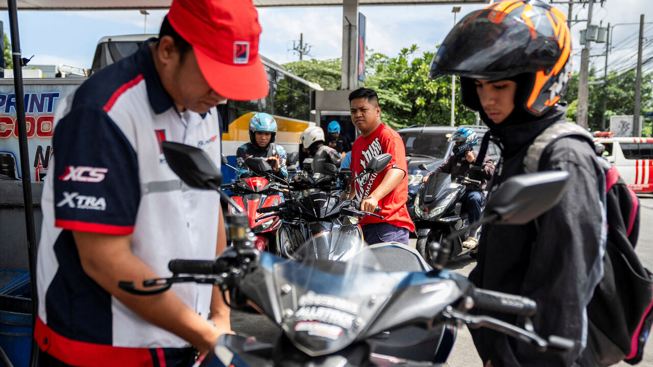 Motorcycle drivers queue while a worker fills up a motorcycle at a gas station as oil prices are expected to increase amid the U.S.-Israel conflict with Iran, in Quezon City, Metro Manila, Philippines, March 9, 2026. REUTERS/Lisa Marie David