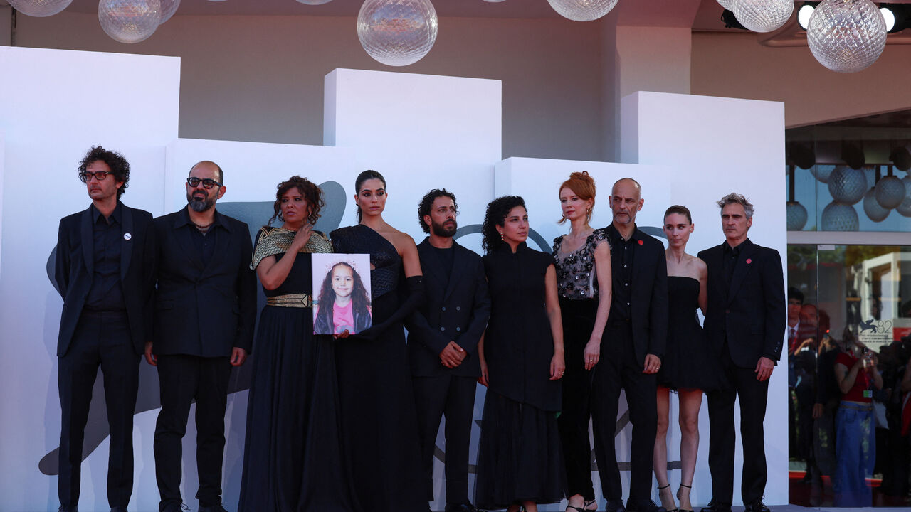 Joaquin Phoenix, Amer Hlehel, Motaz Malhees, Saja Kilani, Clara Khoury, Kaouther Ben Hania, Rooney Mara pose with a picture of Hind Rajab on the red carpet during arrivals for the screening "The Voice of Hind Rajab" in competition, at the 82nd Venice Film Festival, Venice, Italy, September 3, 2025. REUTERS/Yara Nardi