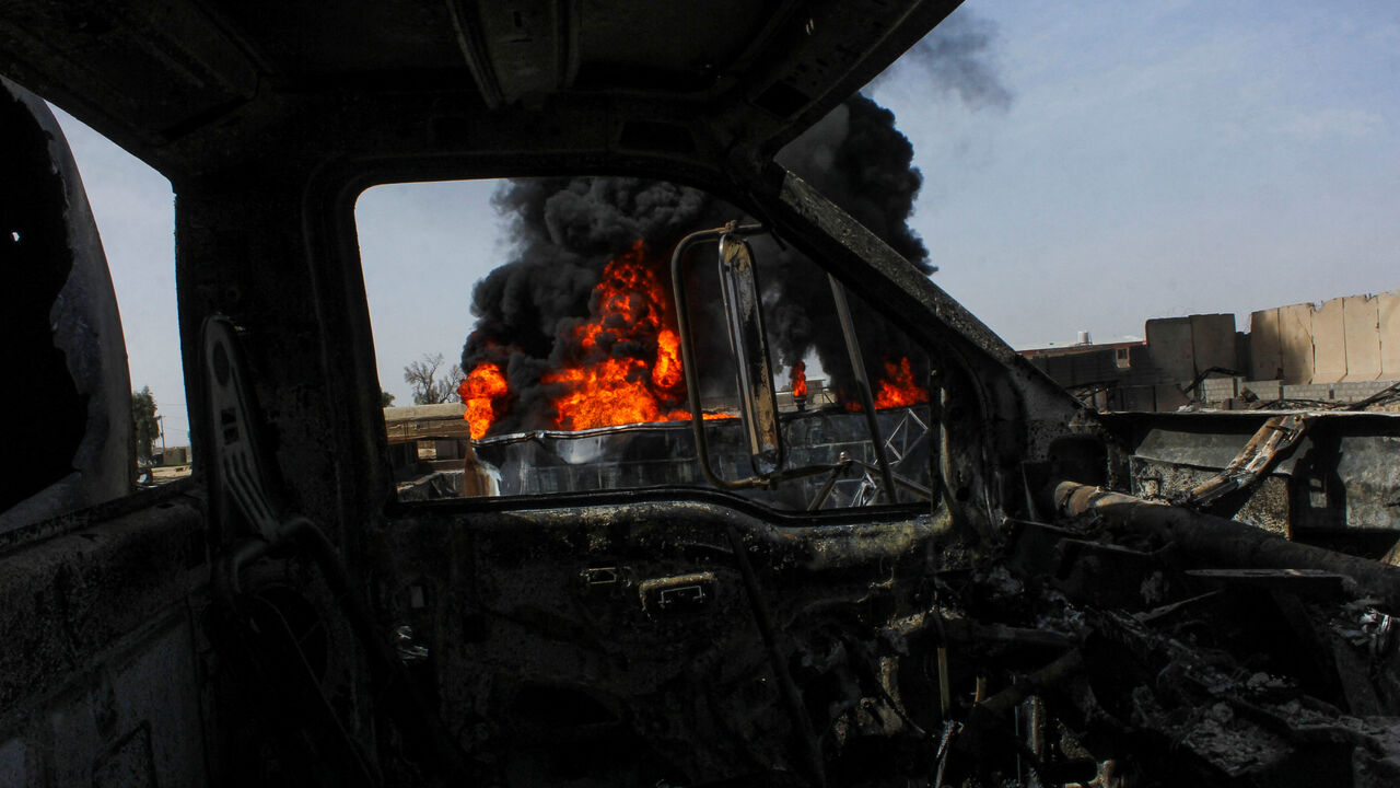 Thick black smoke is seen through a destroyed truck at the private airline Kam Air's fuel depot after a strike in what the Taliban said was a Pakistani air strike, in Kandahar, Afghanistan, March 13, 2026. REUTERS/Stringer