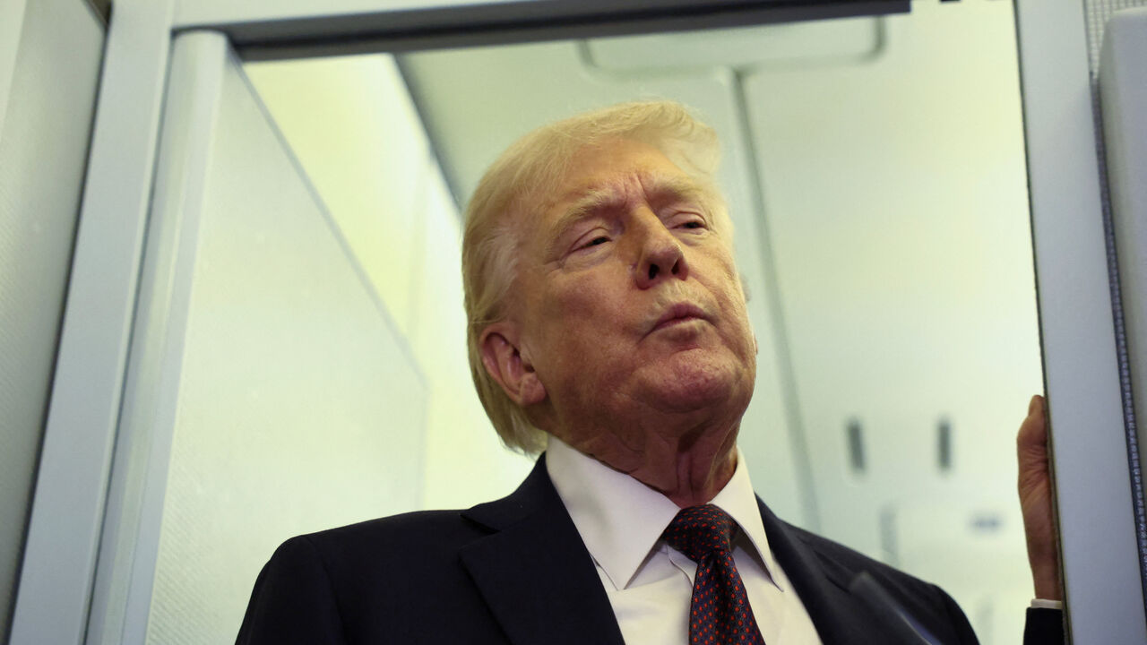 U.S. President Donald Trump speaks to reporters aboard Air Force One on a flight back to Washington March 15, 2026. REUTERS/Kevin Lamarque
