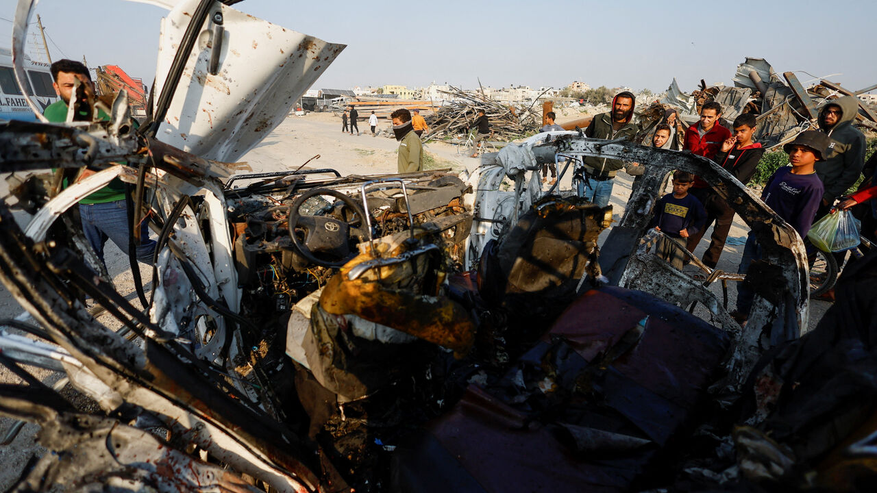 Palestinians inspect the site of an Israeli airstrike targeting a police vehicle in the central Gaza Strip, March 15, 2026. REUTERS/Mahmoud Issa
