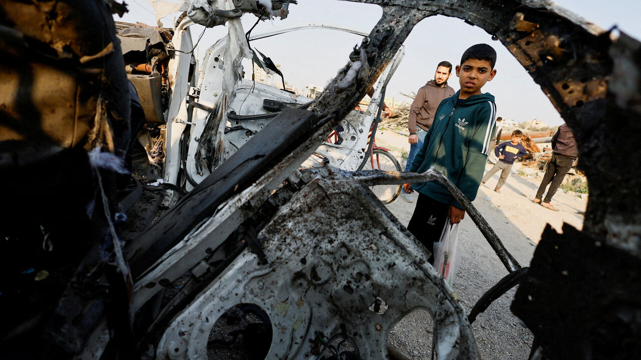 Palestinians inspect the site of an Israeli airstrike targeting a police vehicle in the central Gaza Strip, March 15, 2026. REUTERS/Mahmoud Issa