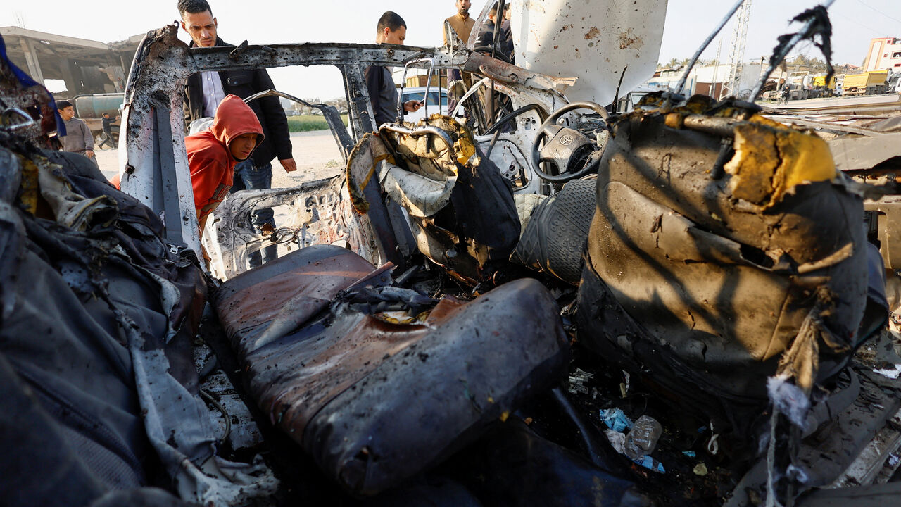 Palestinians inspect the site of an Israeli airstrike targeting a police vehicle in the central Gaza Strip, March 15, 2026. REUTERS/Mahmoud Issa