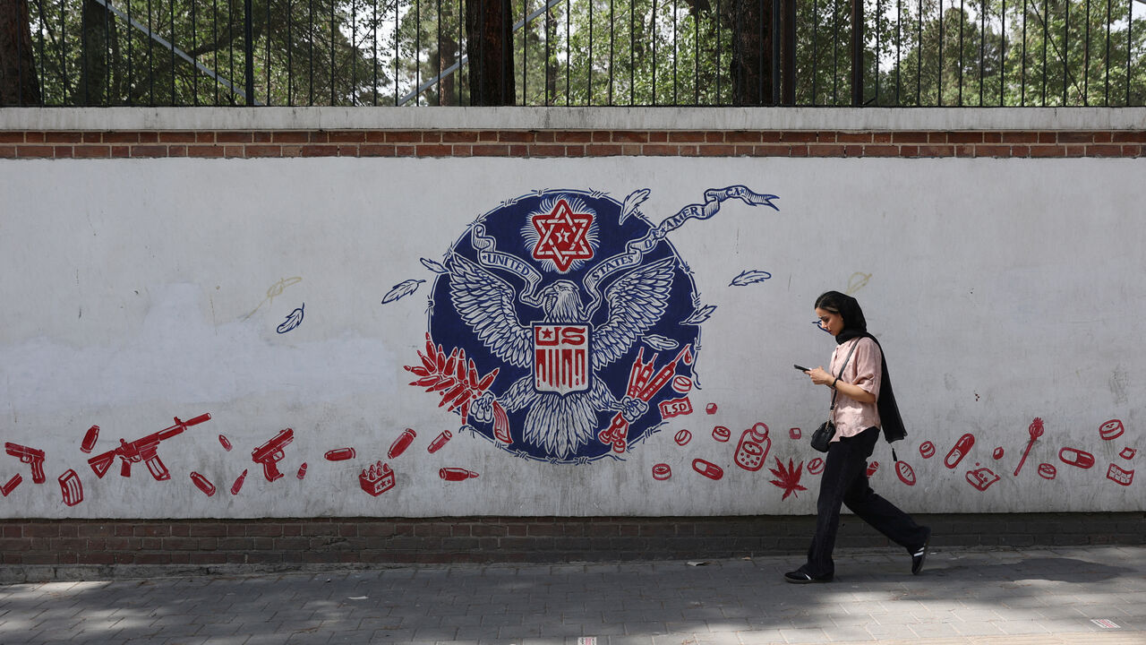 A woman walks past an anti-US mural on a street in Tehran, Iran, June 5, 2025. Majid Asgaripour/WANA (West Asia News Agency) via REUTERS
