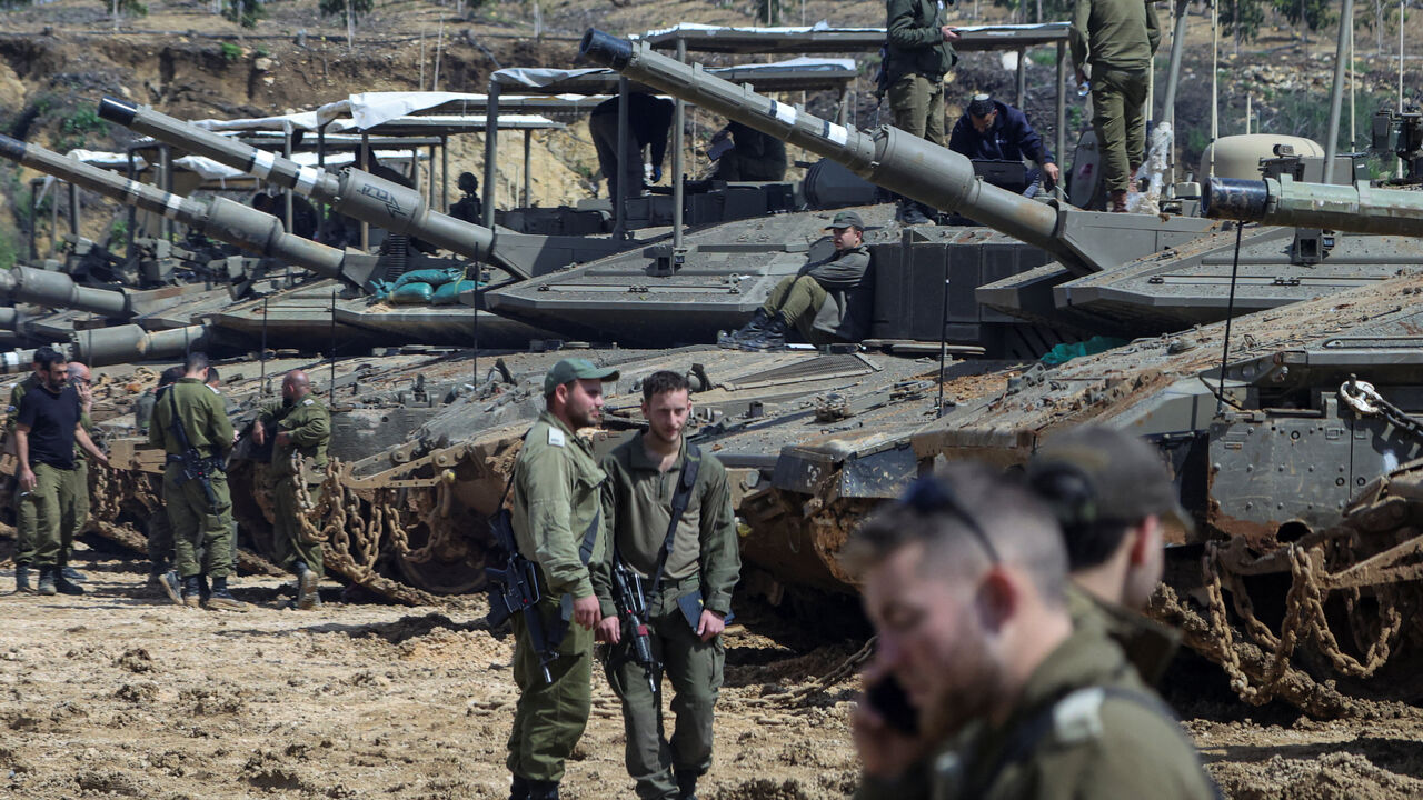 Israeli soldiers stand next to tanks near the Israeli side of the border with Lebanon, amid escalation between Iran-backed Hezbollah and Israel and the U.S.-Israeli conflict with Iran, in northern Israel, March 23, 2026. REUTERS/Tyrone Siu
