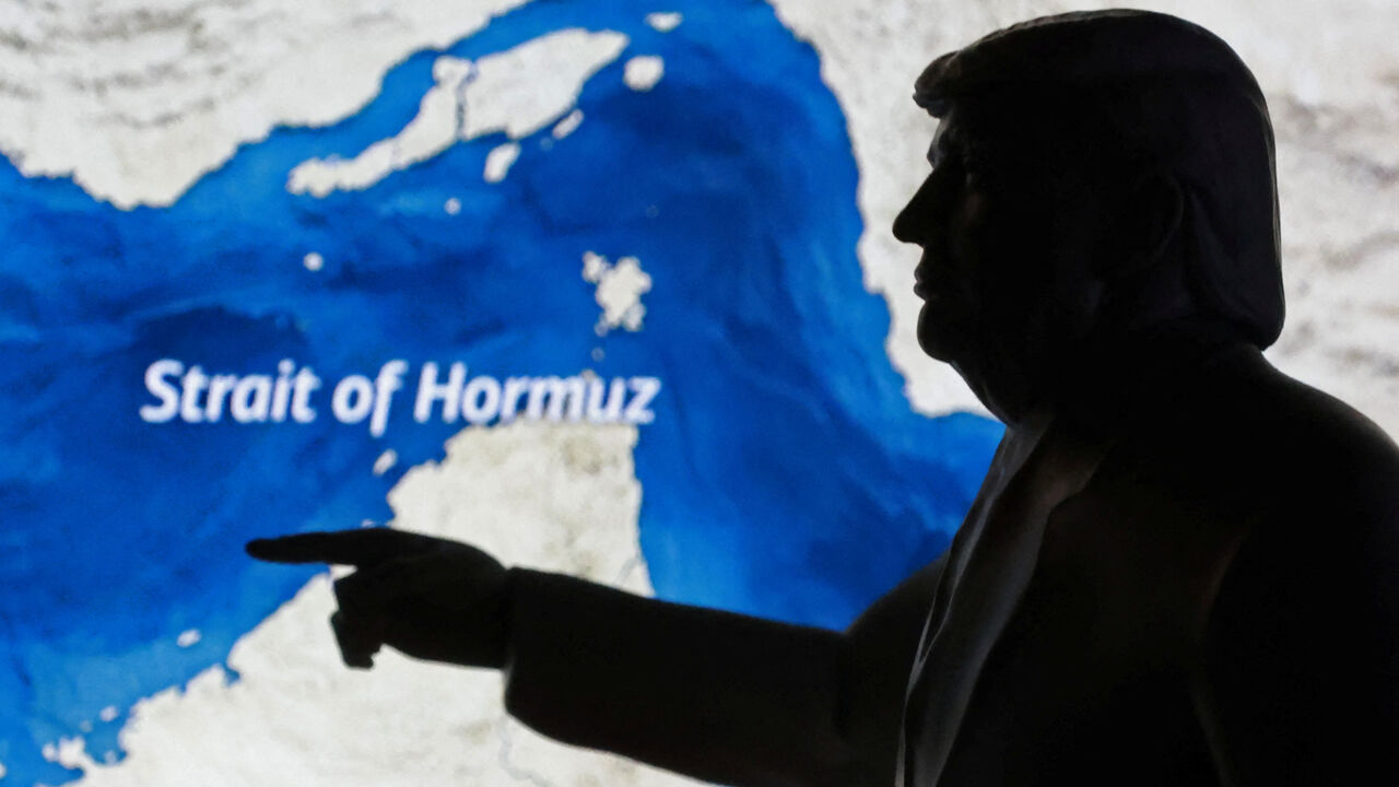 A map showing the Strait of Hormuz and a 3D-printed miniature model depicting U.S. President Donald Trump are seen in this illustration taken March 23, 2026. REUTERS/Dado Ruvic/Illustration