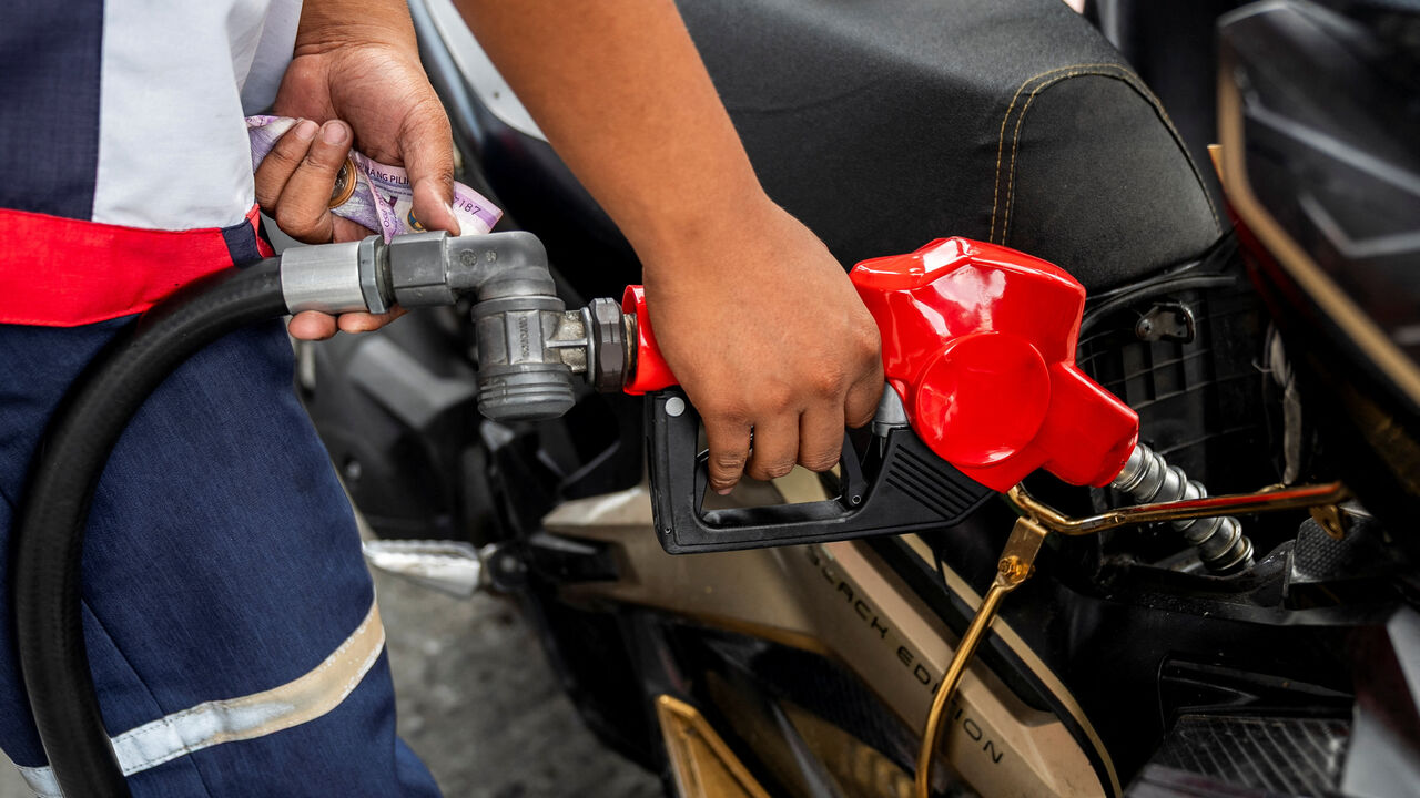 A worker fills up a motorcycle at a gas station as oil prices are expected to increase amid the U.S.-Israel conflict with Iran, in Quezon City, Metro Manila, Philippines, March 9, 2026. REUTERS/Lisa Marie David