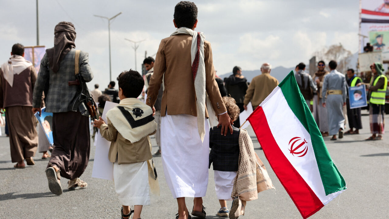 A person walks with children as Houthi supporters demonstrate in solidarity with Iran and Lebanon, amid the U.S.-Israeli conflict with Iran, in Sanaa, Yemen. REUTERS/Khaled Abdullah