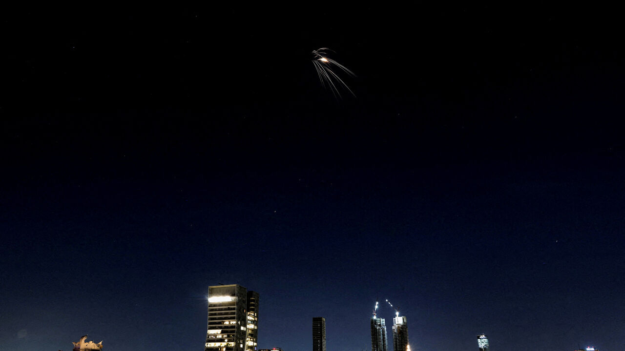FILE PHOTO: An Iranian missile with cluster warhead flies over the city, amid the U.S.-Israeli conflict with Iran, as seen from Tel Aviv, Israel, March 24, 2026. REUTERS/Ronen Zvulun/File Photo