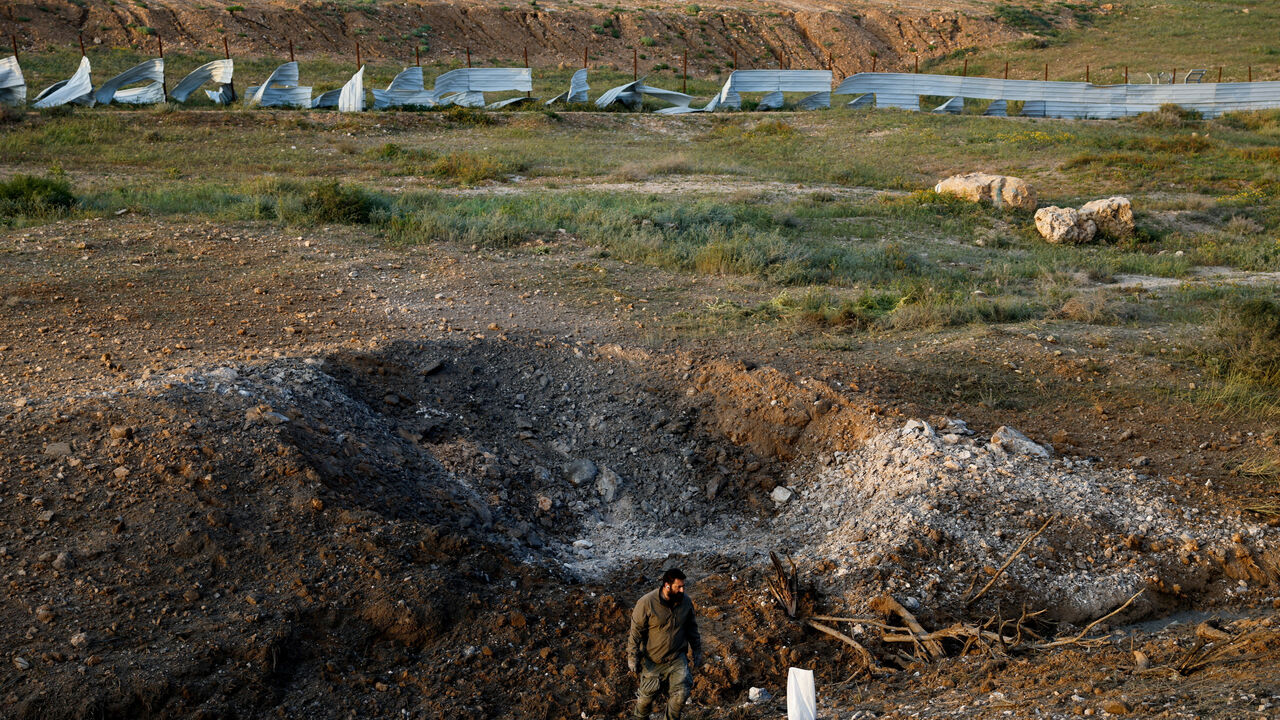 A man stands at an impact site following an Iranian missile strike, as the U.S.-Israeli conflict with Iran continues, in southern Israel, March 29, 2026. REUTERS/Amir Cohen