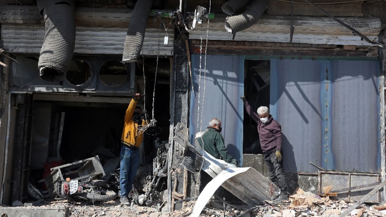 People inspect a damaged building following an airstrike in central Tehran 