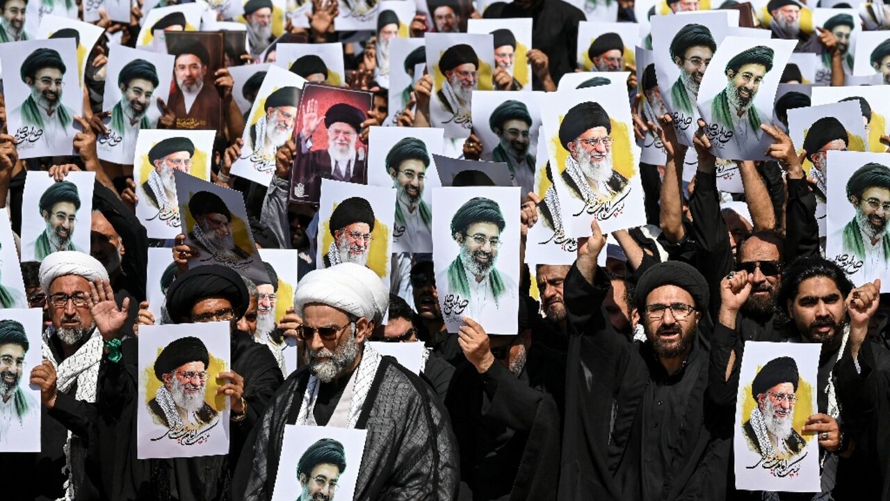 Shia Muslims holding portraits of Iran's slain supreme leader, Ali Khamenei, and his son, new supreme leader Mojtaba Khamenei, shout anti-US and -Israel slogans during a procession in Karachi, Pakistan