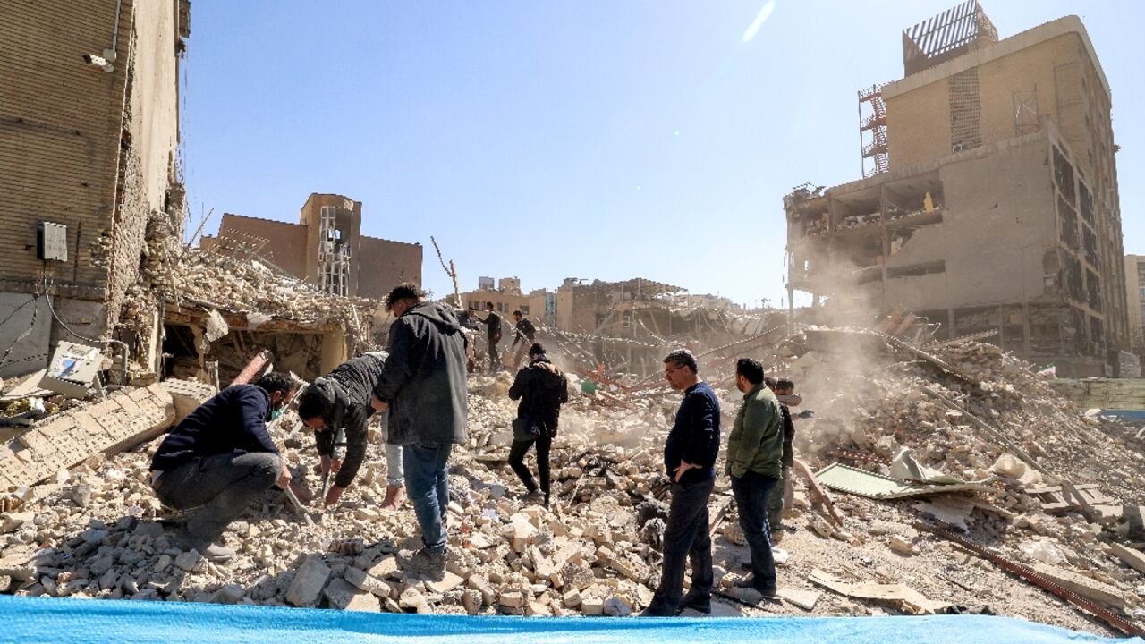 People inspect the rubble of a collapsed building in Tehran. The UN rights chief urged all sides to 'come to their senses' and end the conflict