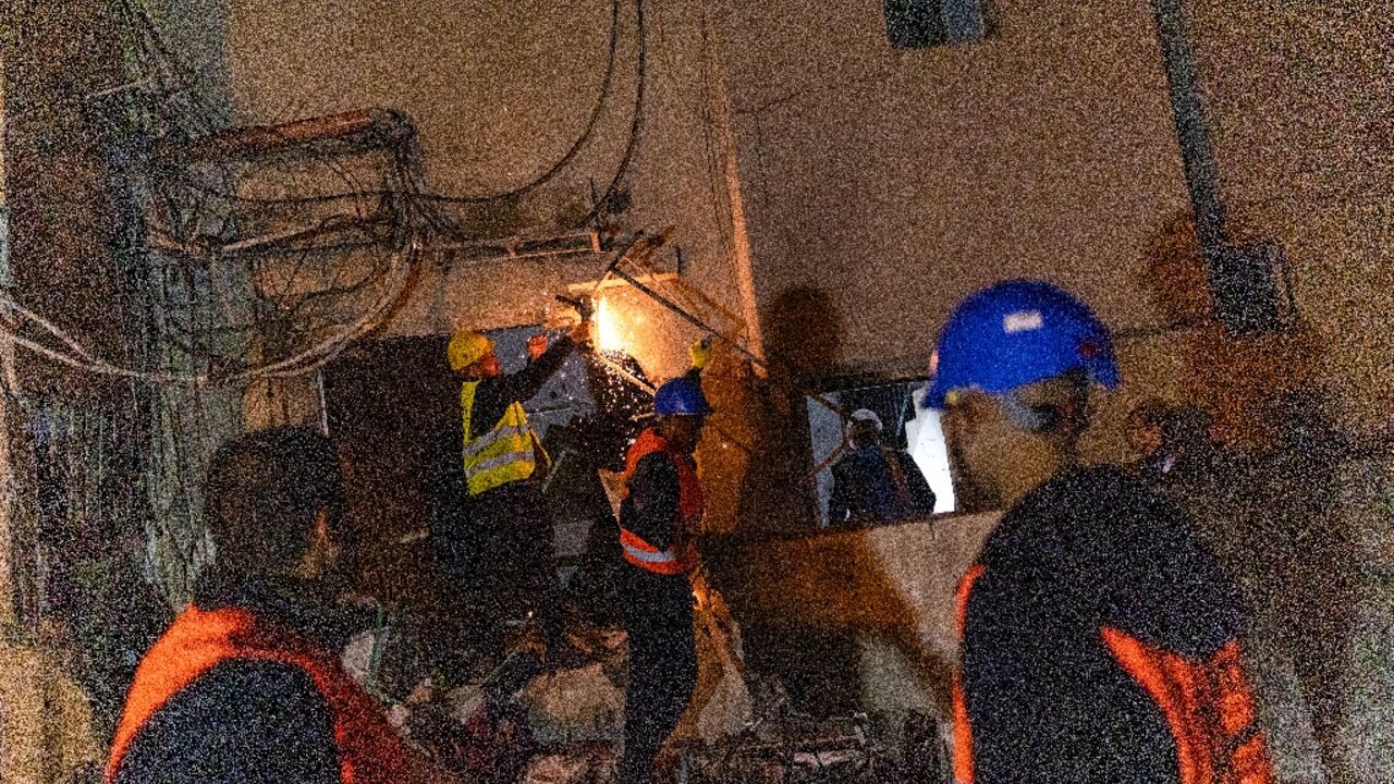 Workers at a building damaged by a strike in Tel Aviv