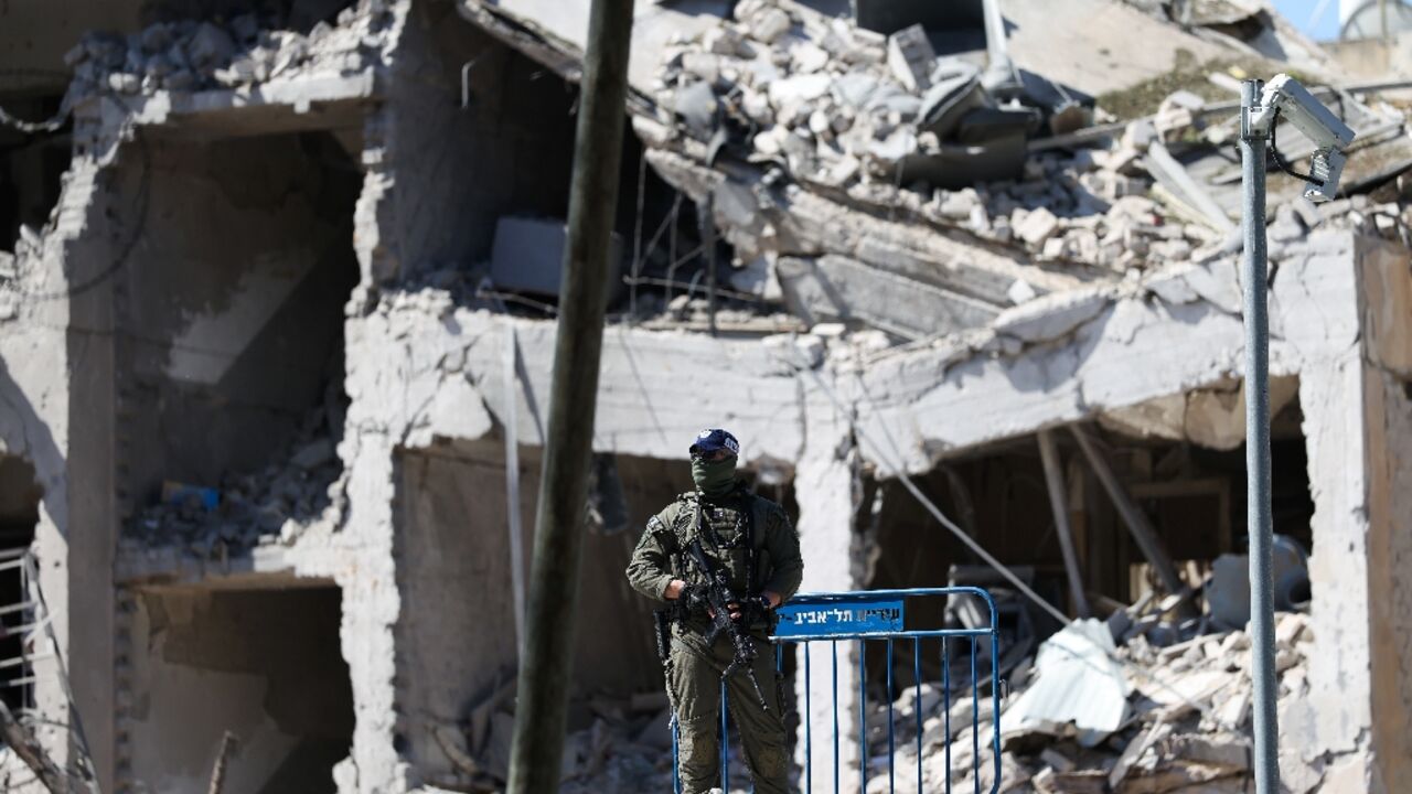 An Israeli soldier guards an area in front of a destroyed building that was hit by a reported overnight Iranian strike in Tel Aviv on March 1, 2026