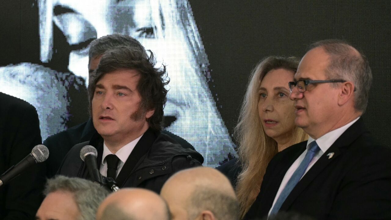 Argentina's President Javier Milei (L) speaks next to Presidency Secretary Karina Milei (2-R) and Israel ambassador to Argentina Eyal Sela (R), during a ceremony to commemorate the 34th anniversary of the 1992 bombing at the Israeli embassy in Buenos Aires 